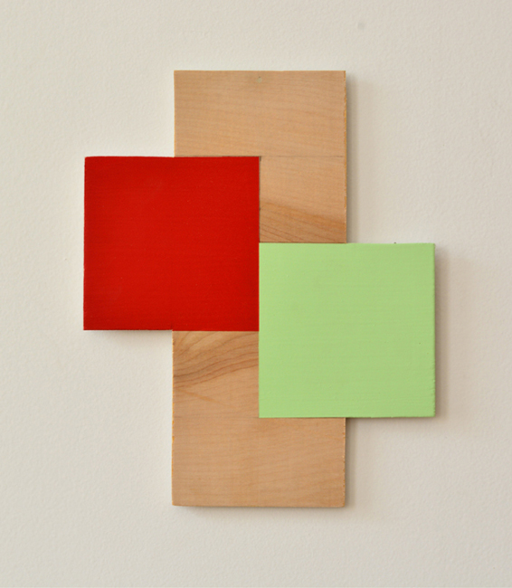 wall relief art work that is of wood and red and green paint